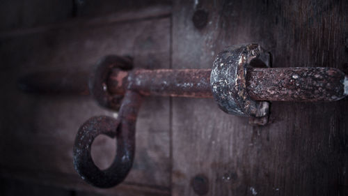 Close-up of rusty padlock on metal door