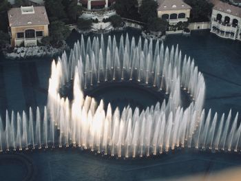 High angle view of illuminated fountain amidst buildings in city