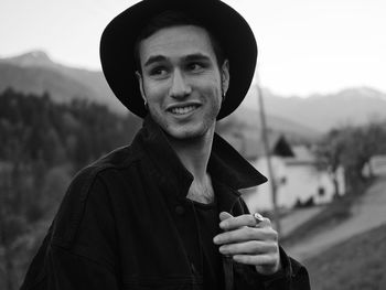 Portrait of young man holding hat