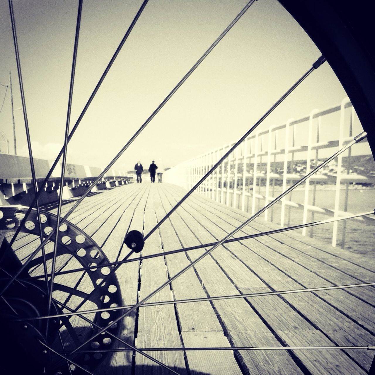 men, transportation, leisure activity, lifestyles, bicycle, mode of transport, travel, person, walking, sunlight, built structure, architecture, railing, shadow, clear sky, medium group of people, sky