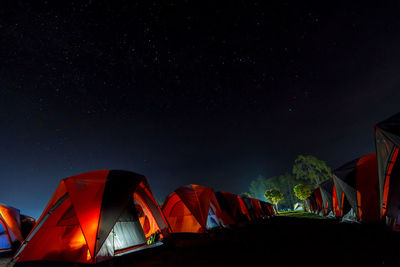 Low angle view of illuminated tent against sky at night