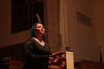 Young woman giving speech at seminar