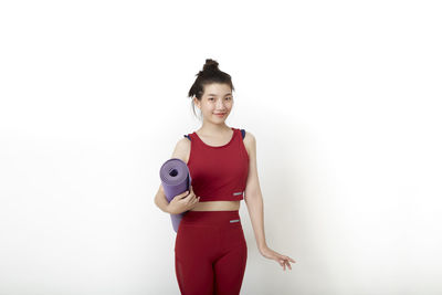 Portrait of smiling young woman against white background