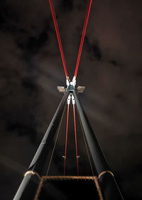 Low angle view of steel bridge against the sky at night
