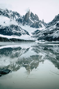Glacial lake with snowcapped mountains in the background in winter