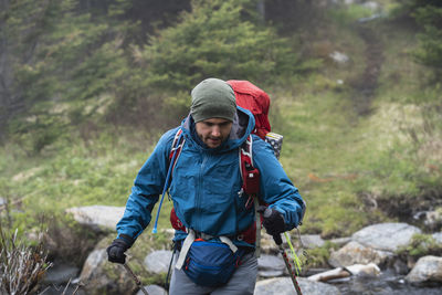 Full length of man standing on rock in forest