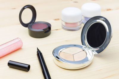 High angle view of make-up products on wooden table