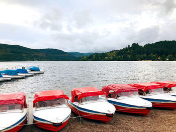 Boats moored in lake against sky