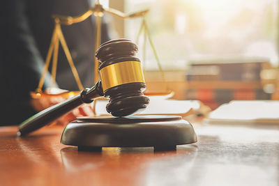 Midsection of judge working at desk with gavel and weight scale