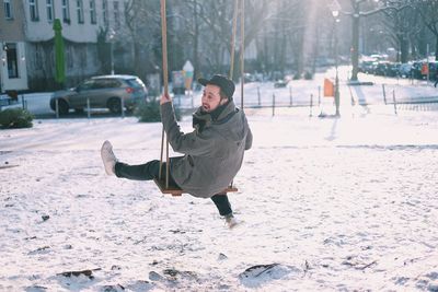 Boy playing on snow covered city