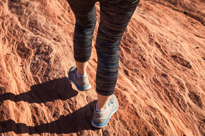 Athletic shoes walking along a rock formation in the desert