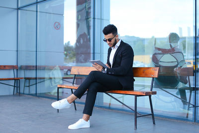 Side view of young man sitting on chair