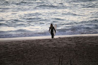 Rear view of silhouette people standing on beach