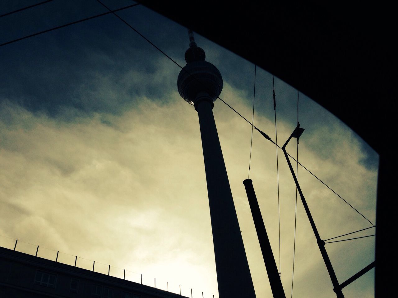 low angle view, sky, built structure, architecture, silhouette, building exterior, street light, tower, tall - high, cloud - sky, dusk, power line, communications tower, lighting equipment, travel destinations, cloudy, cloud, international landmark, connection, famous place