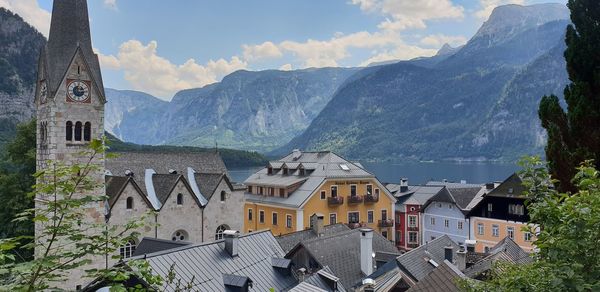 Houses in town by mountains against sky