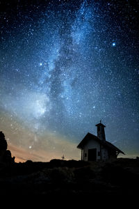 Low angle view of silhouette building against sky at night