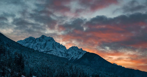 Orange sky and clouds above mountains. alpine landscape.