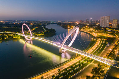 High angle view of light trails on bridge in city against sky at night