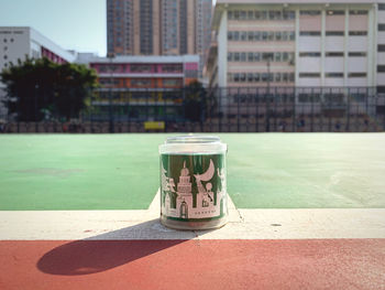 Close-up of drinking glass on table against building