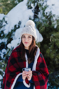 Woman holding coffee cup in snow