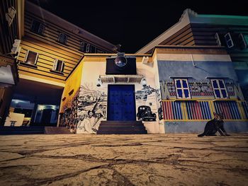 Low angle view of illuminated house by street at night