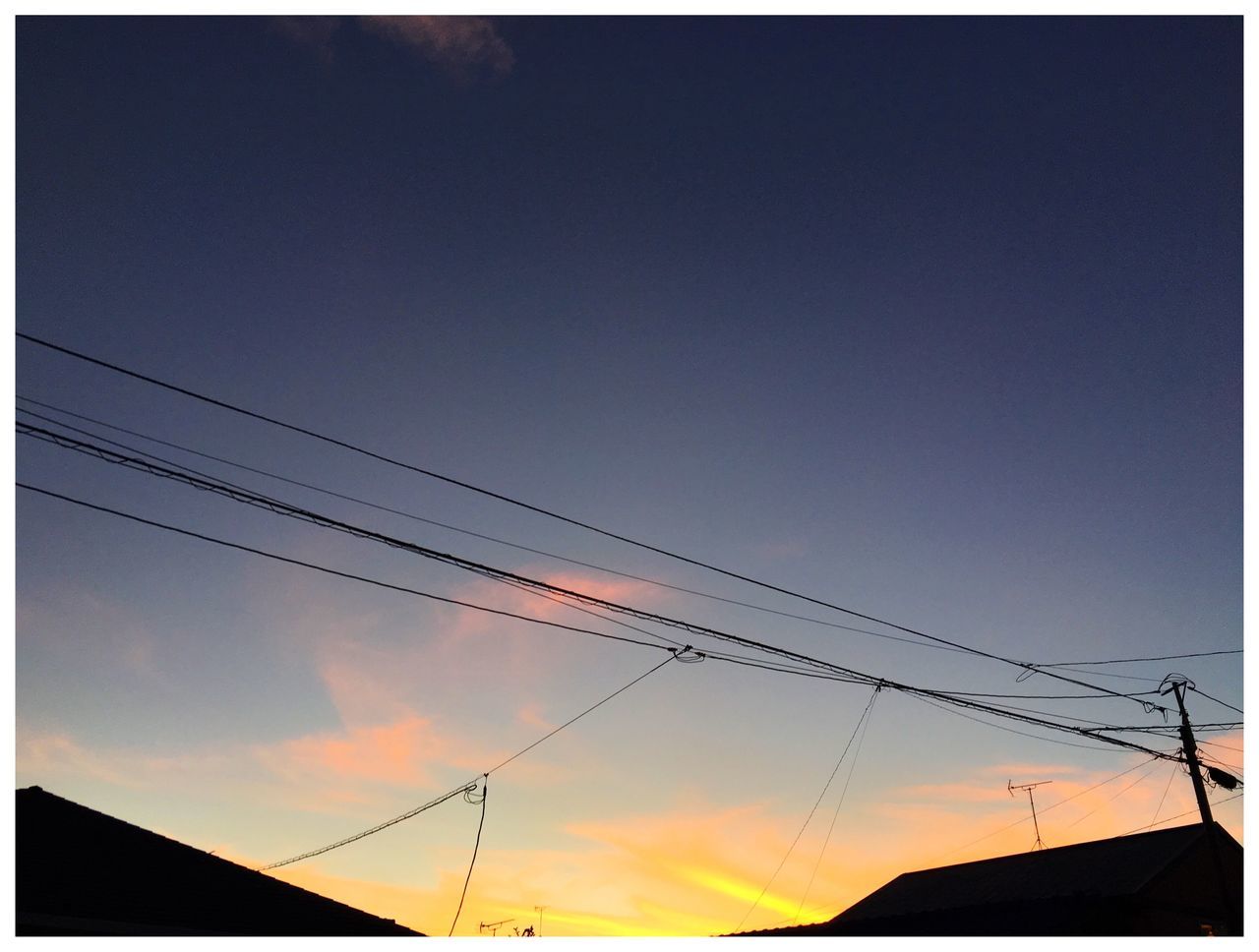 low angle view, power line, sunset, sky, electricity pylon, connection, power supply, electricity, cable, power cable, high section, blue, outdoors, cloud, orange color, nature, no people, beauty in nature, cloud - sky, scenics, tranquility