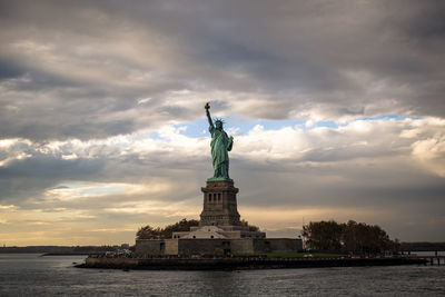 Statue of liberty against cloudy sky