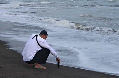 Side view of man standing at beach