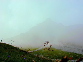 Scenic view of mountains against cloudy sky