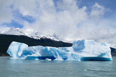 Icebergs in sea against sky