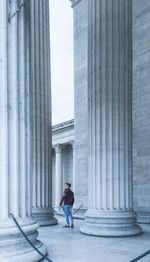 Man standing amidst columns of historic building