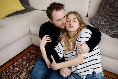 Young couple sitting on sofa at home