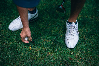 Low section of man playing golf on grass