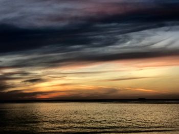 Scenic view of sea against dramatic sky during sunset