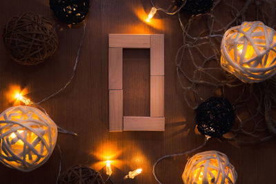 Directly above shot of letter o blocks and illuminated lights on wooden table