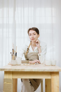 Young woman using mobile phone while sitting at home