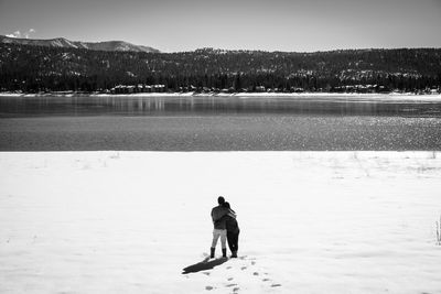 Full length of man on lake against sky during winter