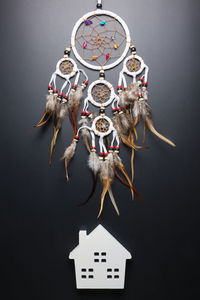 Directly above shot of dreamcatcher and model home against black background