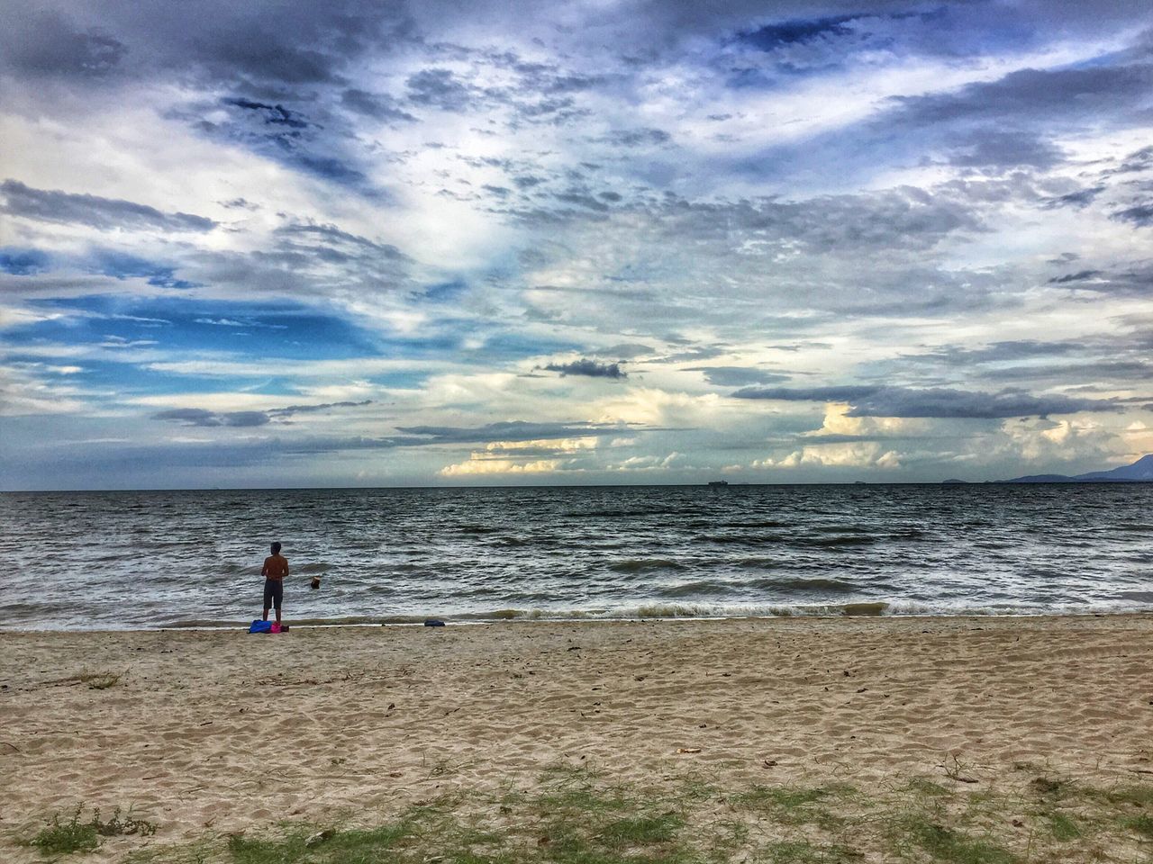 WOMAN ON BEACH AGAINST SKY