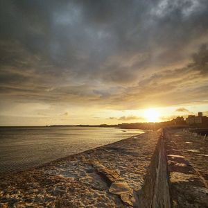 Scenic view of beach against sky during sunset