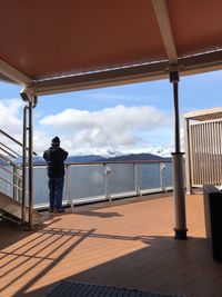 Rear view of man standing at observation point against sky