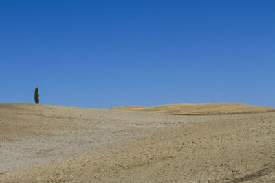 Scenic view of arid landscape against clear blue sky