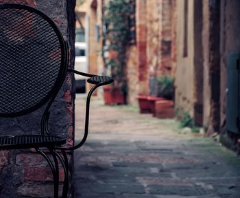 Close-up of empty seats against wall in city