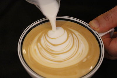 Close-up of hand holding cappuccino