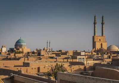 Buildings in city against clear sky