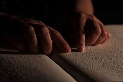 Close-up of human hand on book