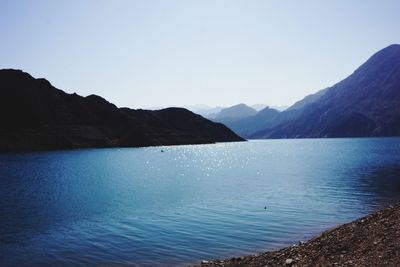 Scenic view of sea and mountains against clear sky