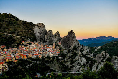 Panoramic view of townscape and mountains against clear sky