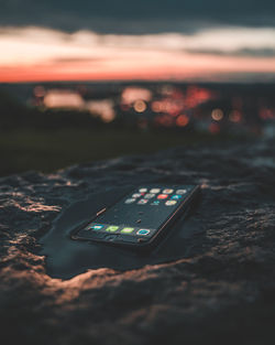 Close-up of illuminated lighting equipment on table against sky during sunset