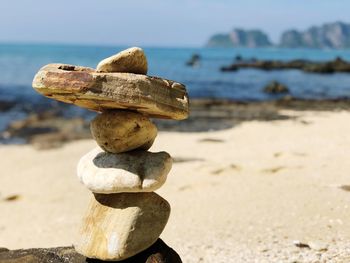 Stack of stones at beach during sunny day